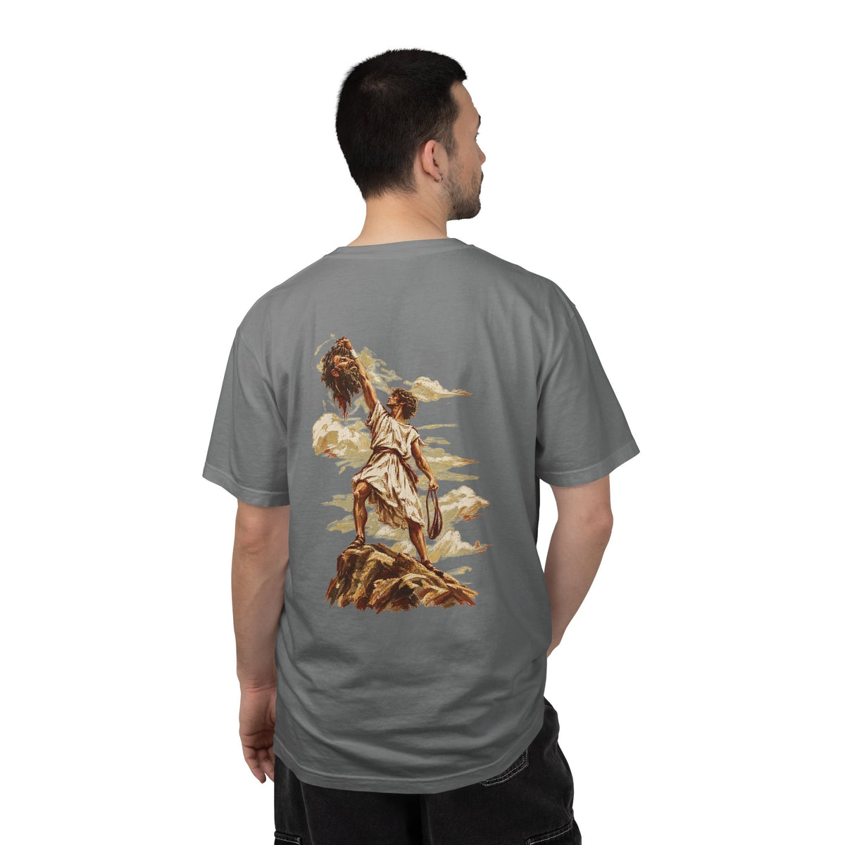 Model wearing a grey David and Goliath Christian T-shirt featuring detailed vintage-inspired biblical artwork of David and Goliath across the back, faith-based Christian streetwear and biblical graphic apparel