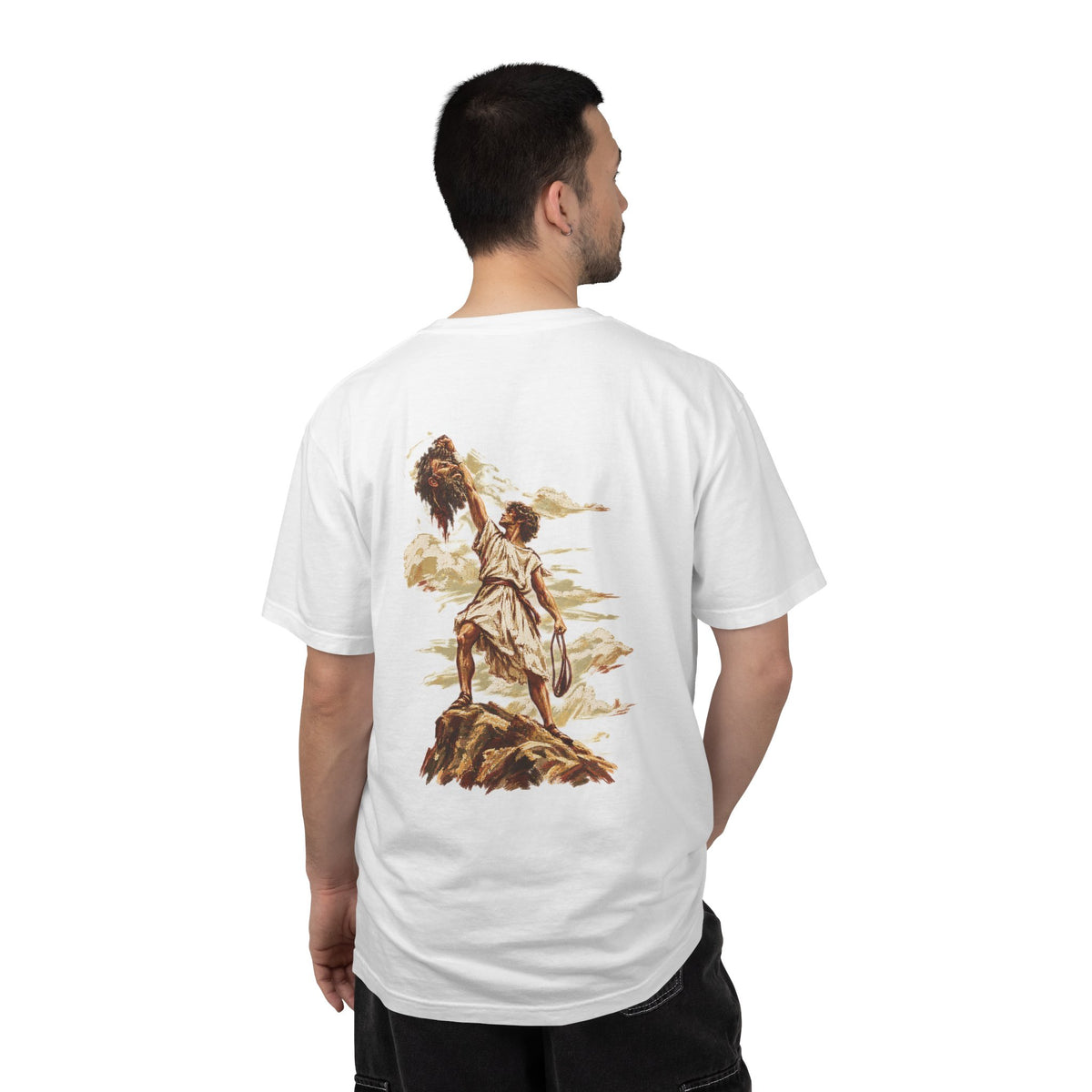 Model wearing a white David and Goliath Christian T-shirt with detailed vintage biblical artwork of David standing over Goliath across the back, faith-inspired graphic apparel